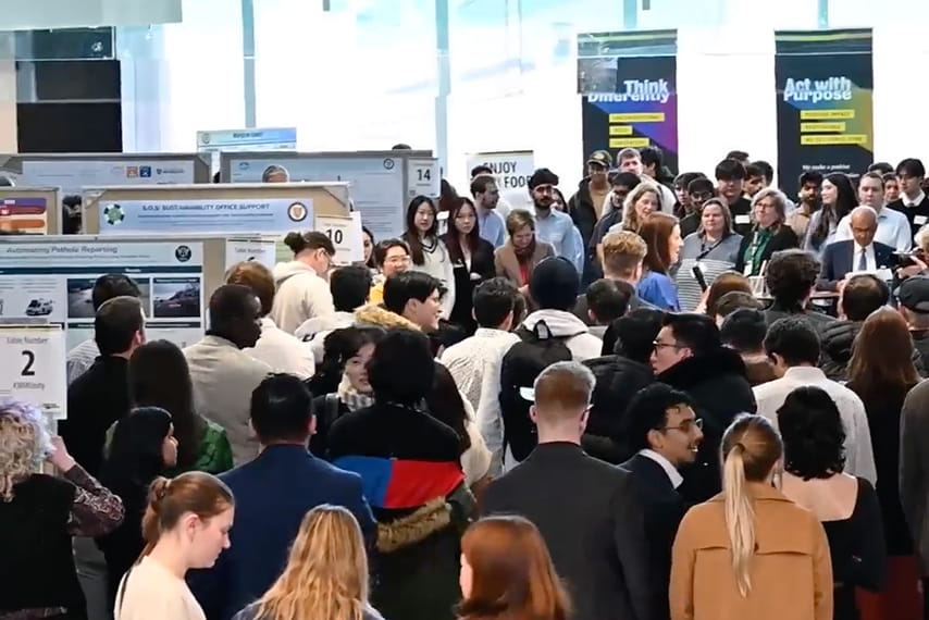 A group of people in a circle listening to a presentation.