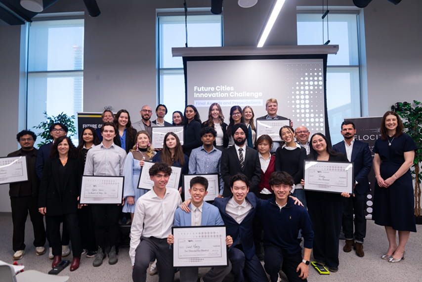 A group of poeple holding diplomas and posing for a photo.